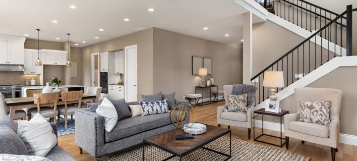 Open concept living room seamlessly integrated with a modern kitchen, featuring neutral tones, ample seating, and contemporary design elements.