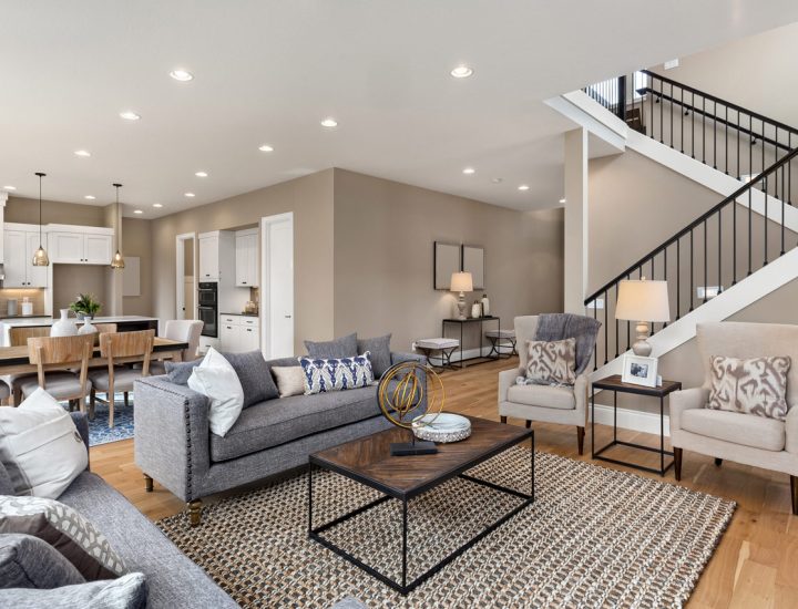 Open concept living room seamlessly integrated with a modern kitchen, featuring neutral tones, ample seating, and contemporary design elements.