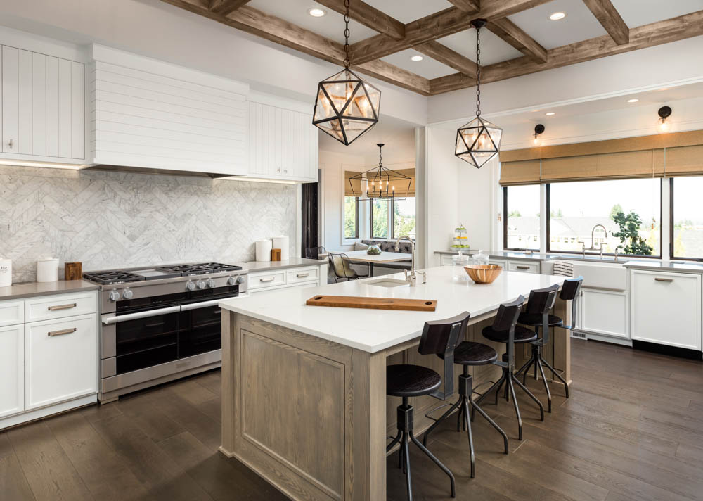 Rustic chic kitchen featuring white cabinetry, a large kitchen island, and wooden ceiling beams, creating a warm and inviting space.